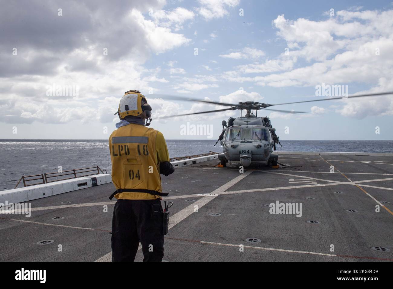 221026-N-XB010-1001 MER DES PHILIPPINES (OCT 26, 2022) – Aviation Boatswain’s Mate (Aircraft Handling) 3rd classe Jaquan Morgan, de Bronx (New York), envoie un signal à un hélicoptère MH-60s Sea Hawk affecté aux « Golden Falcons » de l’Escadron de combat en mer (HSC) 12 pour se tenir rapidement sur le quai de transport amphibie déployé à l’avant USS New Orleans» (LPD 18) Pont de vol en mer des Philippines. La Nouvelle-Orléans, affectée à la Force opérationnelle 76/3, a Uni ses forces avec le Groupe de grève des transporteurs Ronald Reagan pour mener des opérations intégrées combinées avec les forces maritimes du Canada et du Japon afin d'expérimenter le wi Banque D'Images