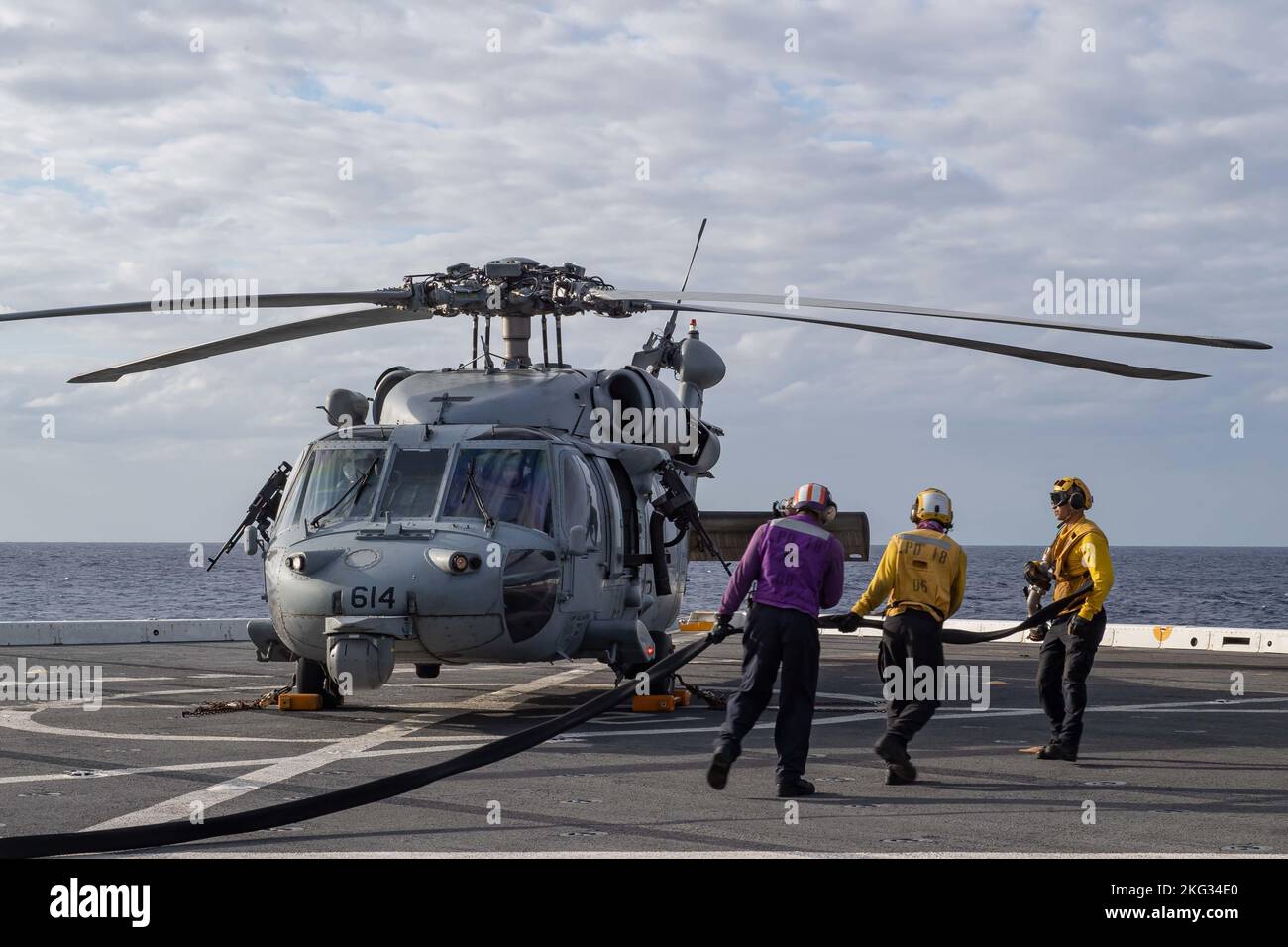 221026-N-XB010-1012 MER DES PHILIPPINES (OCT 26, 2022) – les marins affectés au quai de transport amphibie déployé à l'avant USS New Orleans (LPD 18) transportent une ligne de carburant vers un hélicoptère MH-60s Sea Hawk affecté aux « Golden Falcons » de l'Escadron de combat en mer (HSC) 12 pour le ravitailler en mer des Philippines. La Nouvelle-Orléans, affectée à la Force opérationnelle 76/3, a Uni ses forces avec le Groupe de grève des transporteurs Ronald Reagan pour mener des opérations intégrées combinées avec les forces maritimes du Canada et du Japon afin d'expérimenter des concepts navals à l'appui d'une Indo-Pacifique libre et ouverte. Banque D'Images