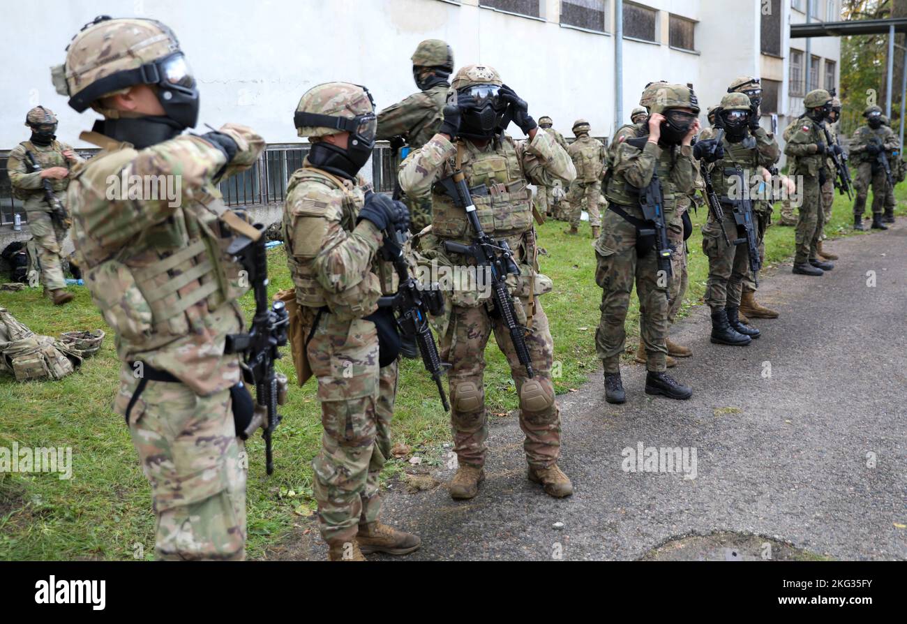 Présence avancée renforcée de l'OTAN les soldats polonais du groupement tactique affectés à la compagnie chaos, 3rd Bataillon, 8th Cavalry Regiment, 3rd Armored Brigade combat Team, 1st Cavalry Division (3-1 ABCT), Aux côtés des forces armées polonaises 5th la Brigade de défense territoriale Mazovienne a mis sur un équipement de protection approprié pour les attaques simulées lors de l'entraînement des opérations urbaines à Komorowo, Pologne, le 26 octobre 2022. L'ABCT de 3-1 est parmi les autres unités assignées à la Division d'infanterie de 1st, travaillant fièrement aux côtés des alliés de l'OTAN et des partenaires de sécurité régionaux pour fournir des forces crédibles au combat au V corps, l'avant-garde de l'Amérique Banque D'Images