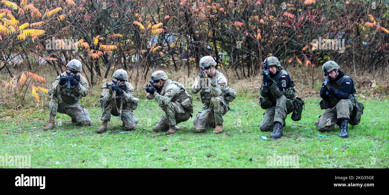 Présence avancée renforcée de l'OTAN les soldats polonais du groupement tactique affectés à la compagnie chaos, 3rd Bataillon, 8th Cavalry Regiment, 3rd Armored Brigade combat Team, 1st Cavalry Division (3-1 ABCT), Aux côtés des forces armées polonaises 5th la Brigade Mazovienne de la Défense territoriale répète les techniques de tir à partir de la position à genoux lors d'un entraînement d'opérations urbaines à Komorowo, Pologne, 26 octobre 2022. L'ABCT de 3-1 est parmi les autres unités assignées à la Division d'infanterie de 1st, travaillant fièrement aux côtés des alliés de l'OTAN et des partenaires de sécurité régionaux pour fournir des forces crédibles au combat au V corps, la guerre d'avant de l'Amérique Banque D'Images