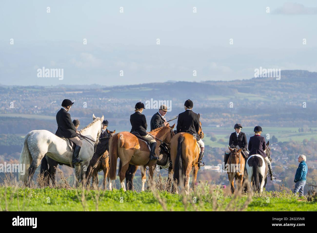 Vue arrière de chasseurs sur des chevaux au milieu d'un tour de chasse au renard dans la campagne britannique. Les gens à cheval pendant leur chasse au renard en Angleterre. Banque D'Images