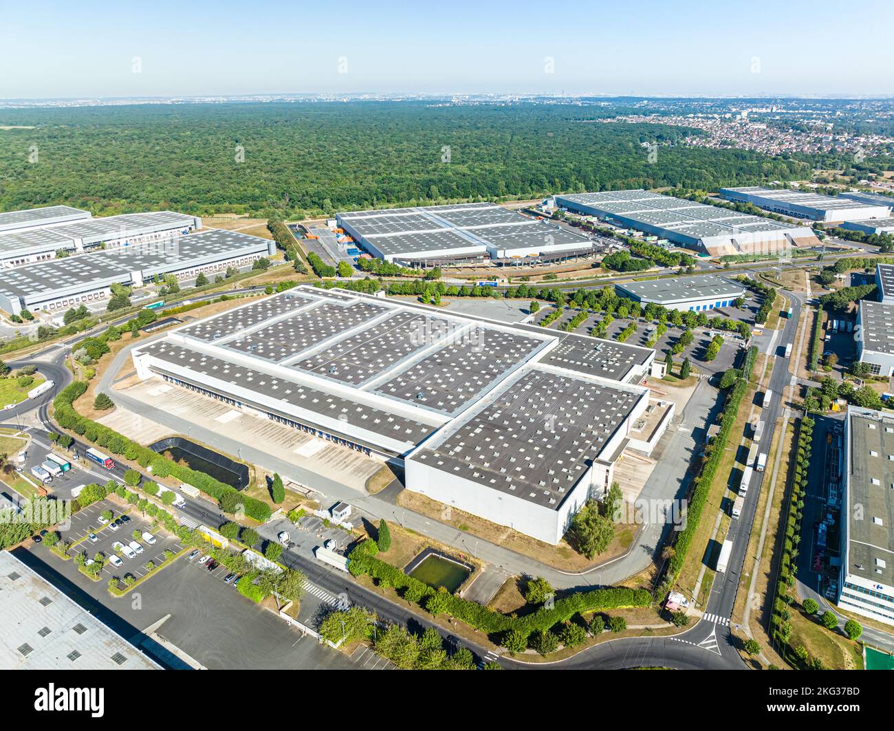 Vue en perspective d'une zone commerciale entourée de végétation luxuriante et de routes développées à proximité de diverses propriétés Banque D'Images