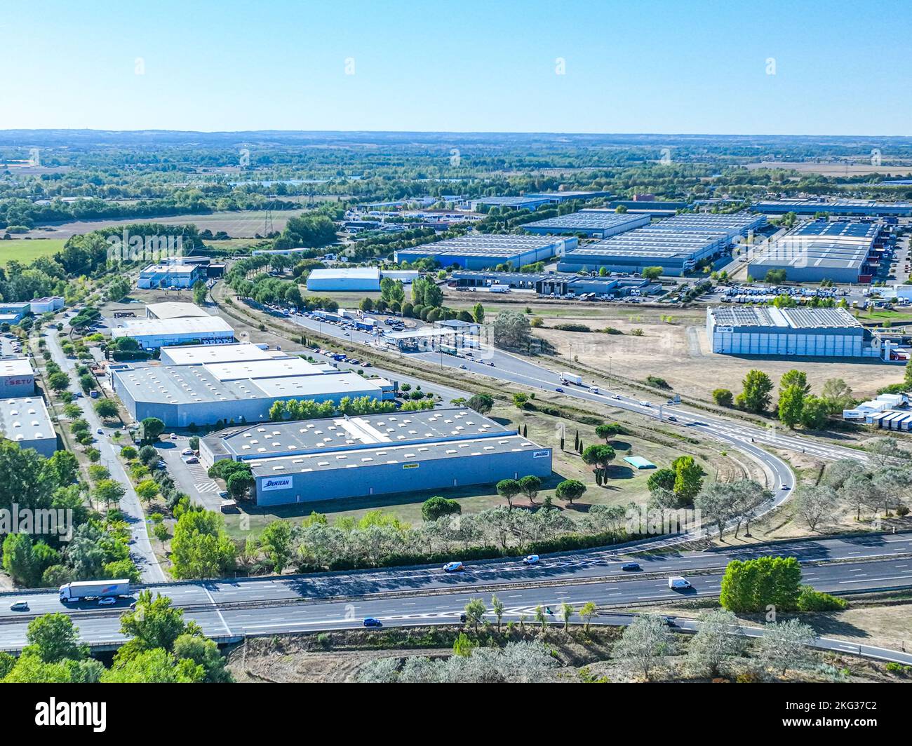 Vue panoramique de propriétés d'entrepôt entouré de verdure luxuriante près de l'autoroute nationale à Toulouse, France Banque D'Images