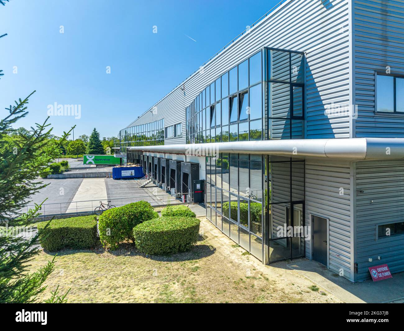 Photo horizontale d'un nouveau bureau commercial avec porte d'entrée et fenêtres en verre le matin Banque D'Images