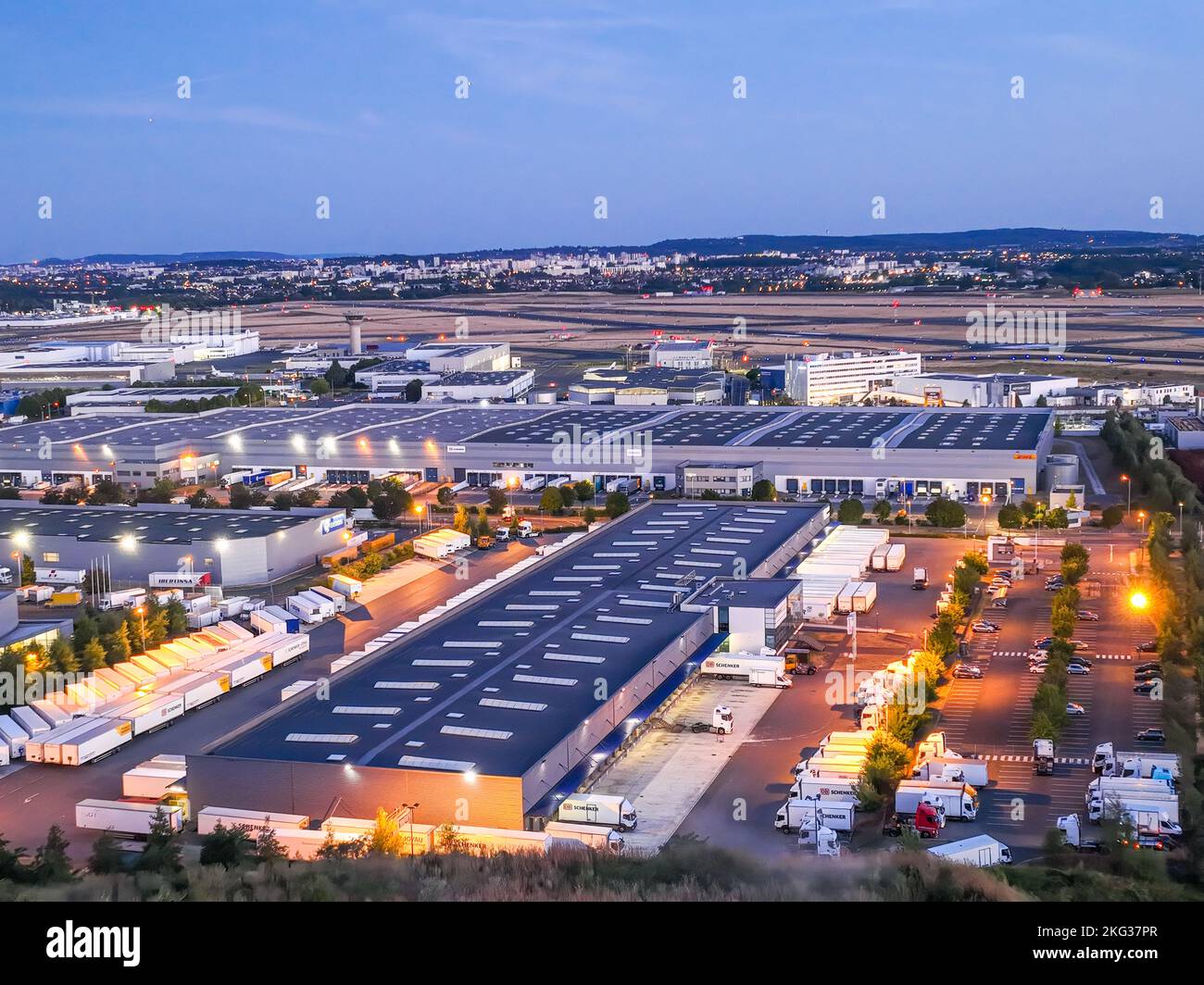 Vue aérienne des bâtiments d'entrepôt où sont stationnés des camions dans la baie de chargement la nuit Banque D'Images