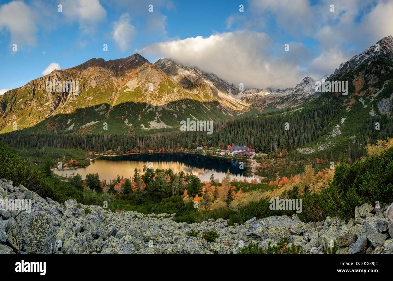 Magnifique lac de montagne Popradske pleso avec ses reflets Forêt d'automne, Hautes Tatras en arrière-plan Banque D'Images