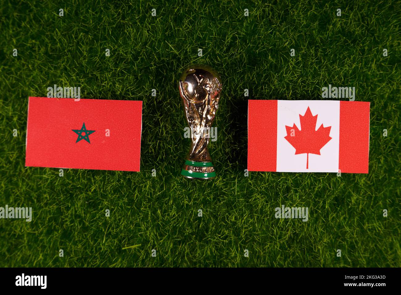 20 novembre 2022, Doha, Qatar. Drapeaux du Maroc et du Canada et trophée de la coupe du monde de la FIFA sur la pelouse verte du stade. Banque D'Images