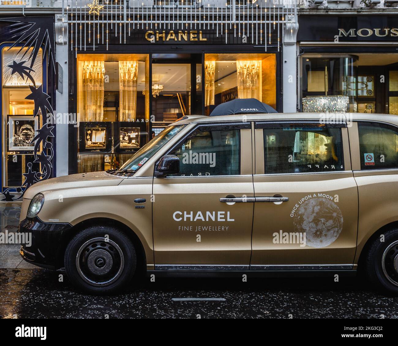 Un taxi londonien emblématique portant la marque Chanel devant le magasin Chanel de Mayfair, Londres. Banque D'Images