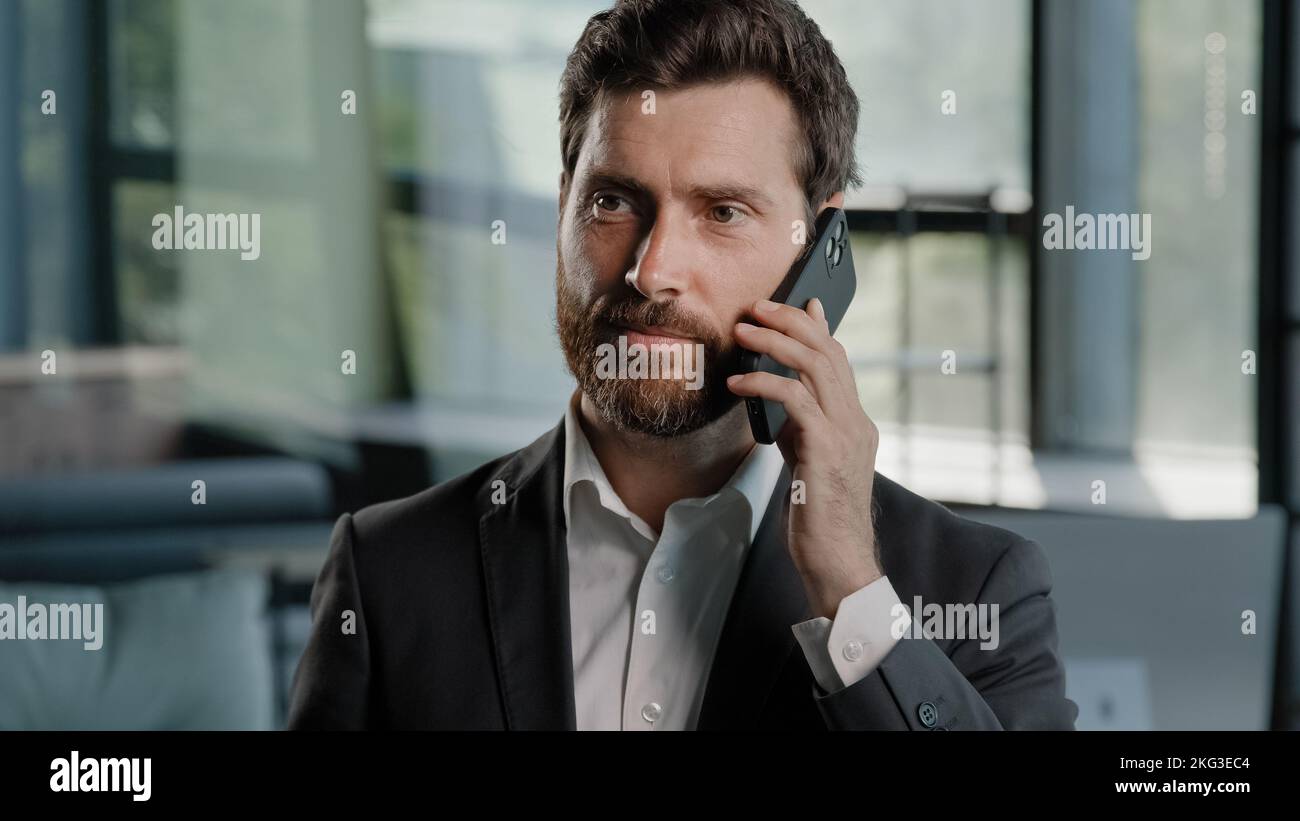 Portrait barbu caucasien d'âge moyen homme d'affaires parlant téléphone au bureau négocier la conversation de vente virtuelle en utilisant mobile homme professionnel Banque D'Images