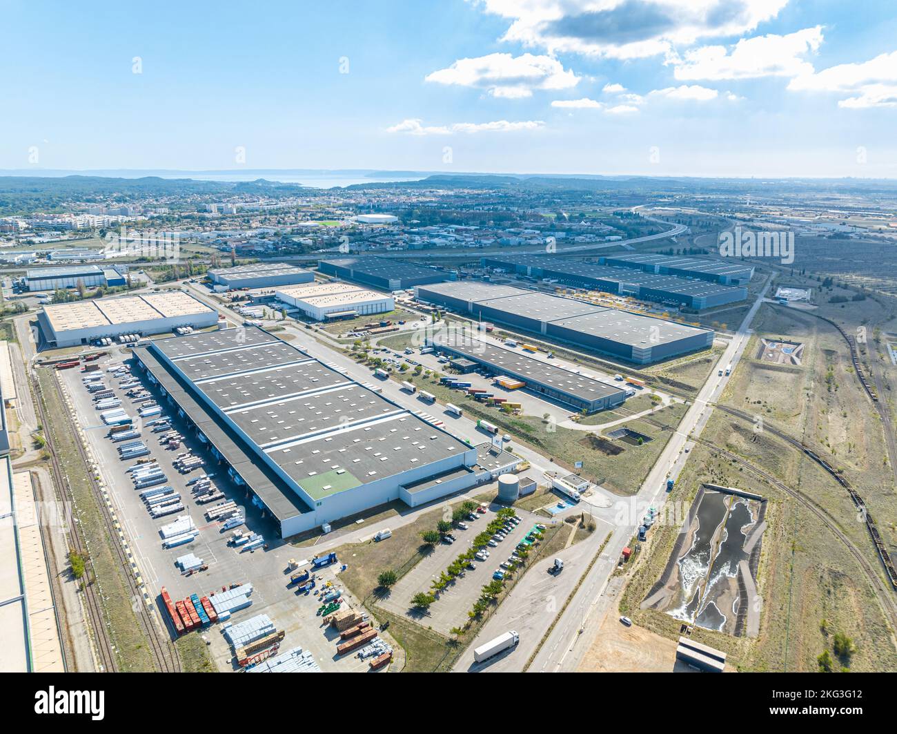 Vue aérienne de l'immense zone industrielle développée avec des camions stationnés dans la baie de chargement le long de Grans, France Banque D'Images