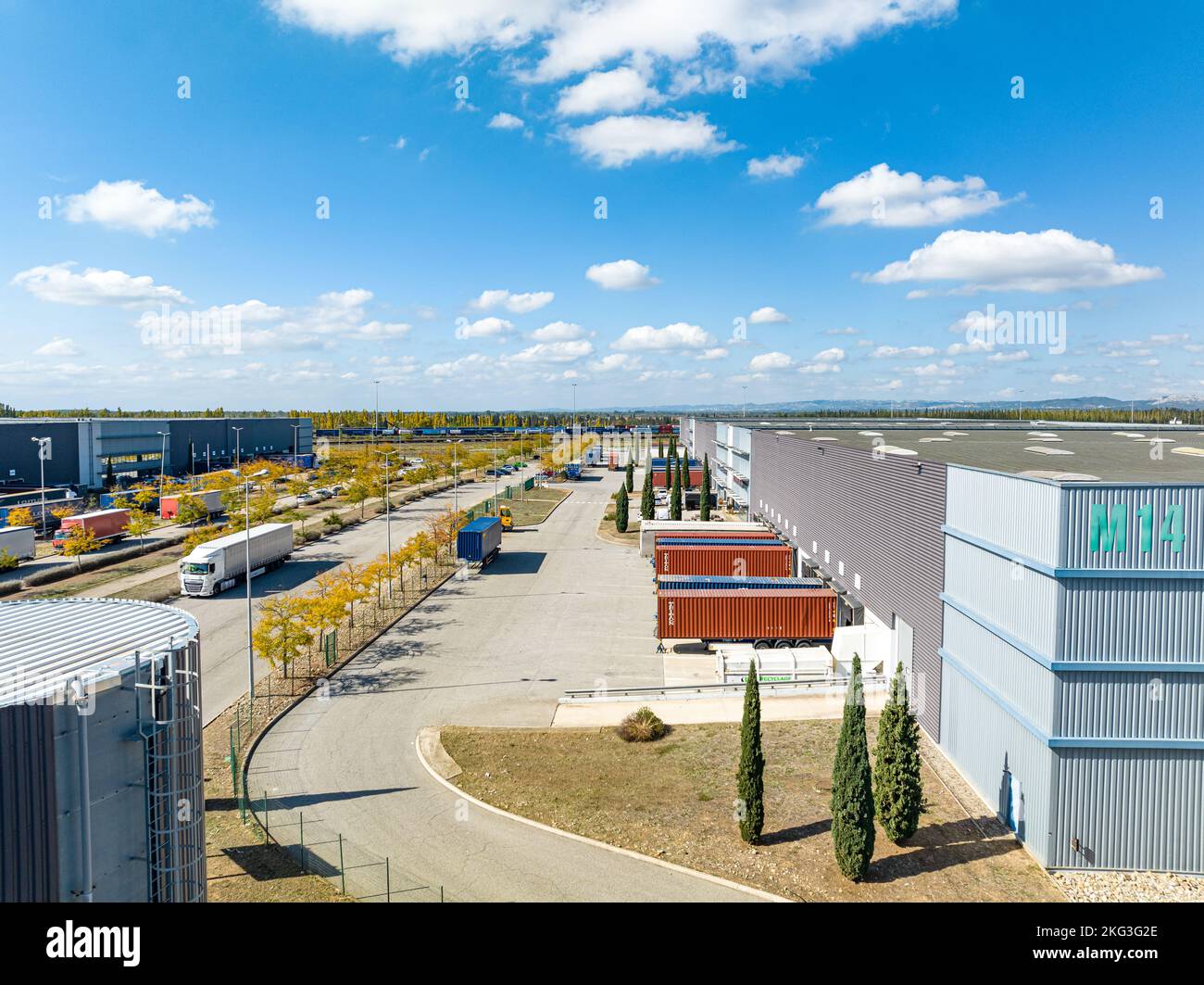 Tir de drone de la zone extérieure de l'entrepôt entouré de véhicules chargés avec des stocks et garés en rangée Banque D'Images