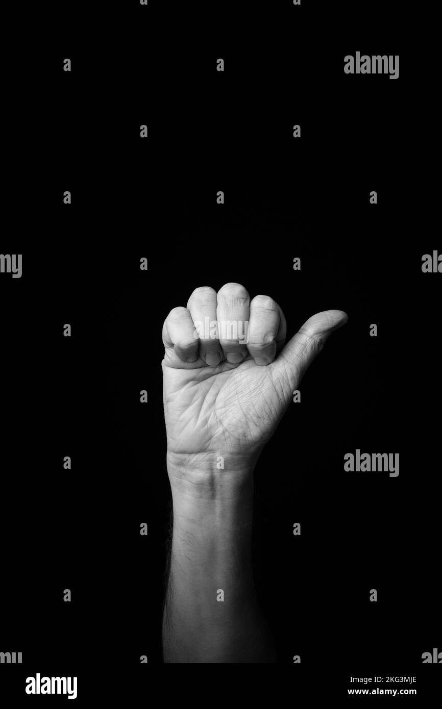 Image noire et blanche dramatique d'une main masculine qui orthographie la lettre « A » du langage du signe Fench, isolée sur un fond sombre avec un espace de copie Banque D'Images Image noire et blanche dramatique d'une main masculine qui orthographie la lettre « A » du langage du signe Fench, isolée sur un fond sombre avec un espace de copie Banque D'Images