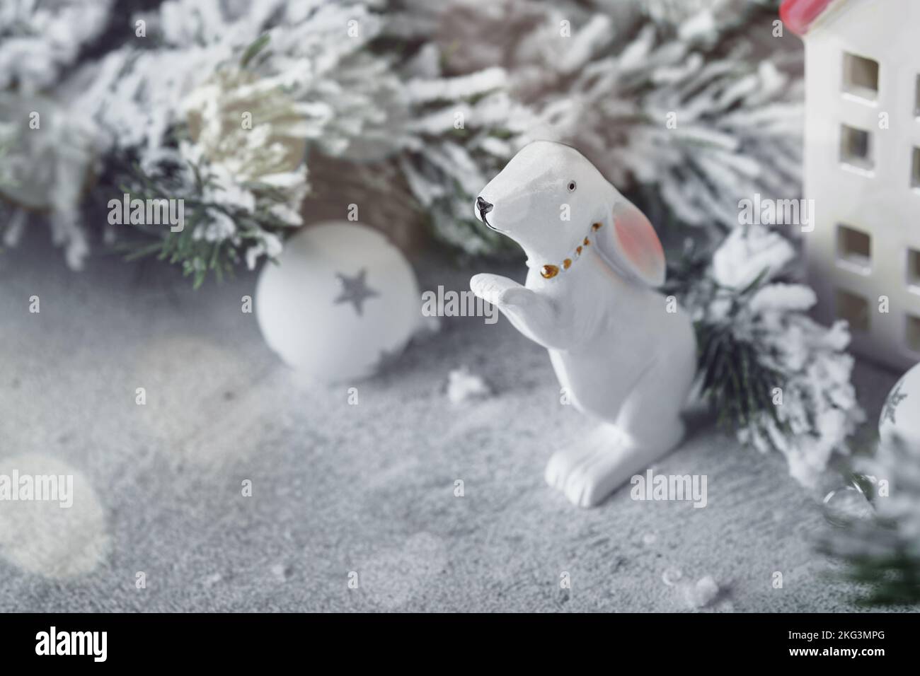 Noël. Carte de vacances du nouvel an. Noël. Les maisons coxy enveloppées d'un foulard blanc et symbole de l'année sont le lapin blanc avec des branches d'arbre de Noël dans le sno Banque D'Images