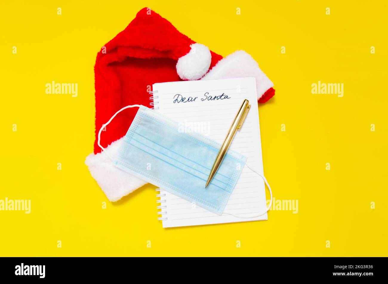 Lettre au Père Noël avec le masque sur fond jaune. Cher signe du Père Noël avec chapeau de Père Noël. Plat de Noël Banque D'Images