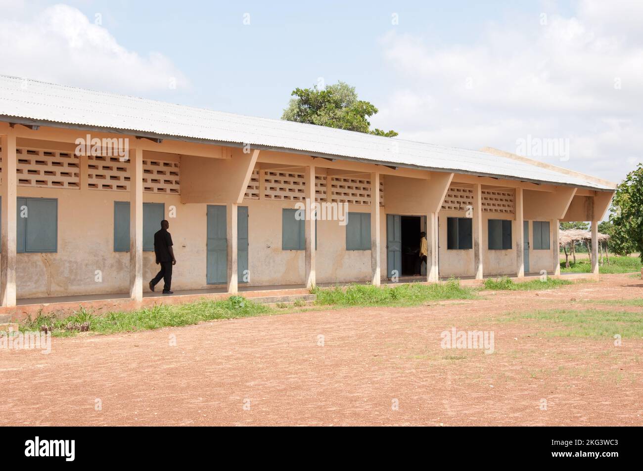 Classes de l'école primaire; Coubly, Atacora, Bénin. Professeur marchant le long du couloir. Banque D'Images