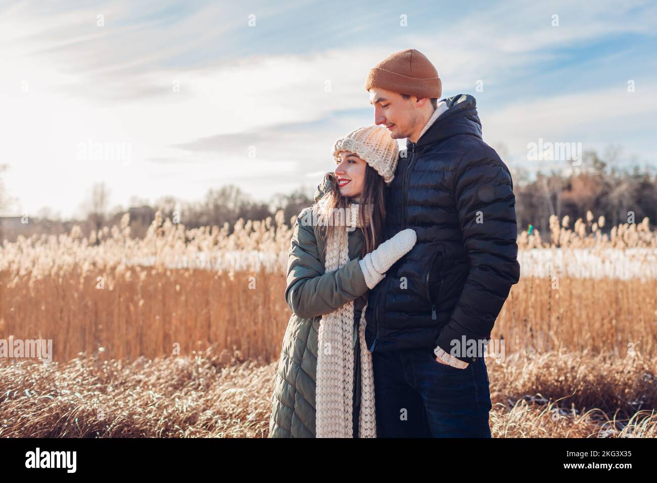 Portrait d'un jeune couple aimant marchant sur la rivière d'hiver. Homme et femme qui s'embrasse en plein air en profitant d'un paysage enneigé Banque D'Images