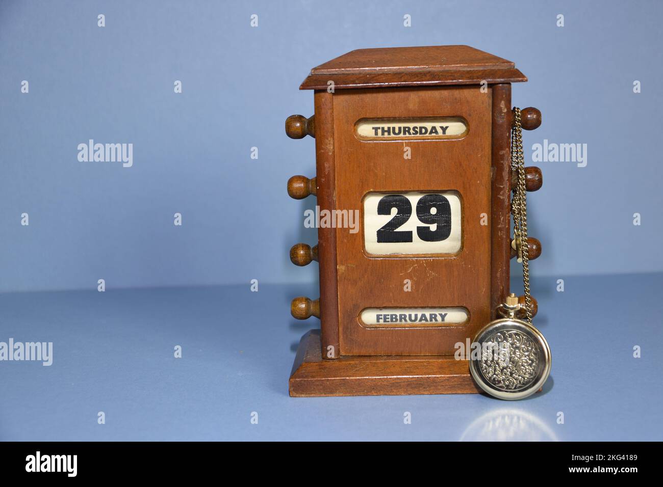 Calendrier de bureau antique montrant la date du prochain saut année jour 02.29.2024 avec la montre de poche dorée prêtée contre elle et la chaîne drapée sur le réglage de date Banque D'Images