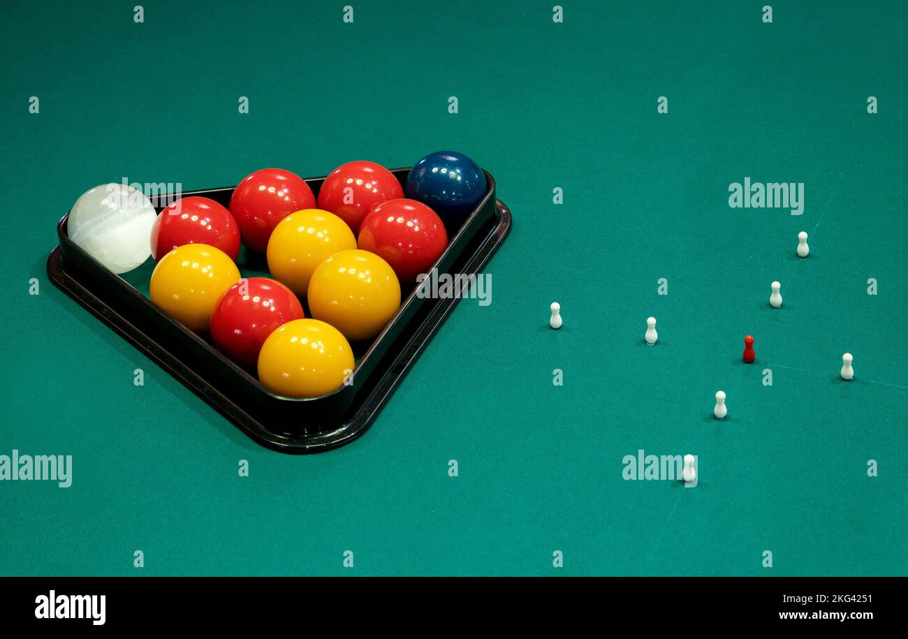 Du dessus du triangle rack avec des boules placées près des patinettes disposées en croix sur la table de billard verte Banque D'Images