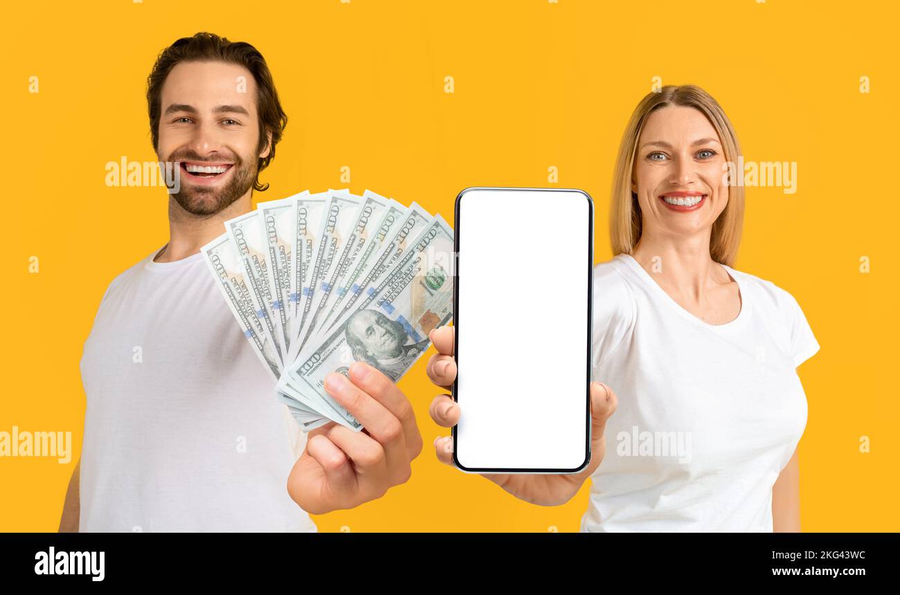 Jeune femme et homme européen souriant avec un smartphone et de l'argent Banque D'Images