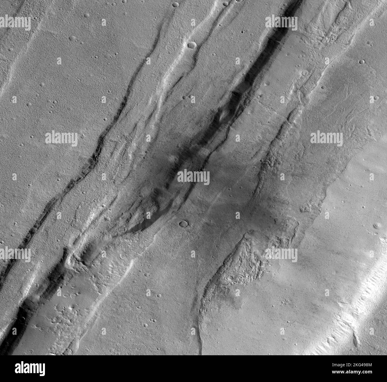 Context Camera affiche un cratère d'impact Mars dans Tempe Terra. Ce cratère d'impact météoroïde sur Mars a été capturé à l'aide de la caméra de contexte noir et blanc à bord de l'orbiteur de reconnaissance Mars (MRO) de la NASA. La caméra de contexte a pris cette image montrant l'impact, qui s'est produit le 18 septembre 2021, dans une région appelée Tempe Terra. Le météoroïde a frappé le côté d'un graben, une dépression créée par des failles. Le cratère d'impact qui se trouve derrière se trouve à environ 130 mètres (427 pieds). Banque D'Images