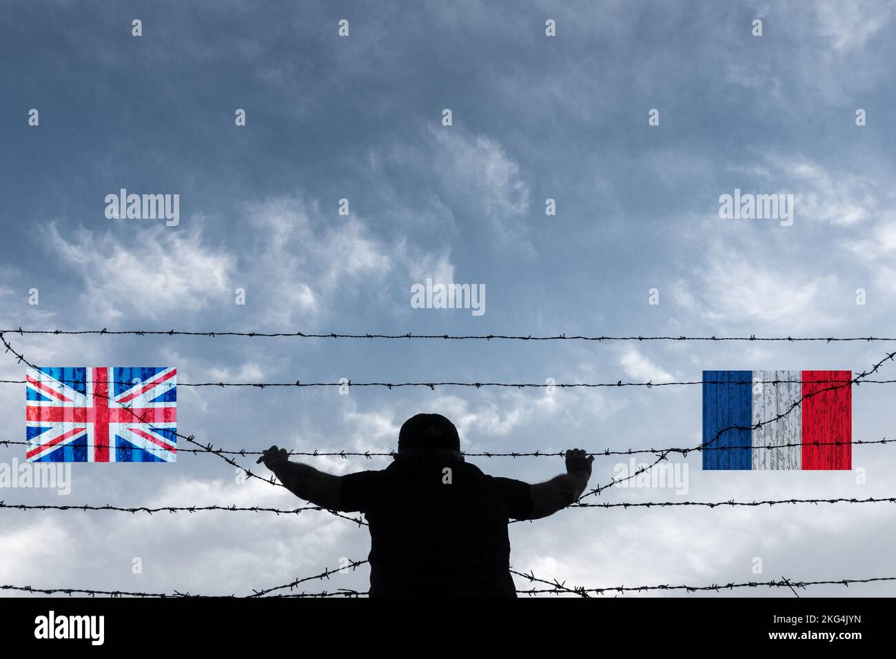 Homme regardant à travers la clôture barbelée sur les drapeaux de plage du Royaume-Uni et de la France. Contrôle des frontières, passage des canaux, migrants, demandeur d'asile, immigration... Banque D'Images