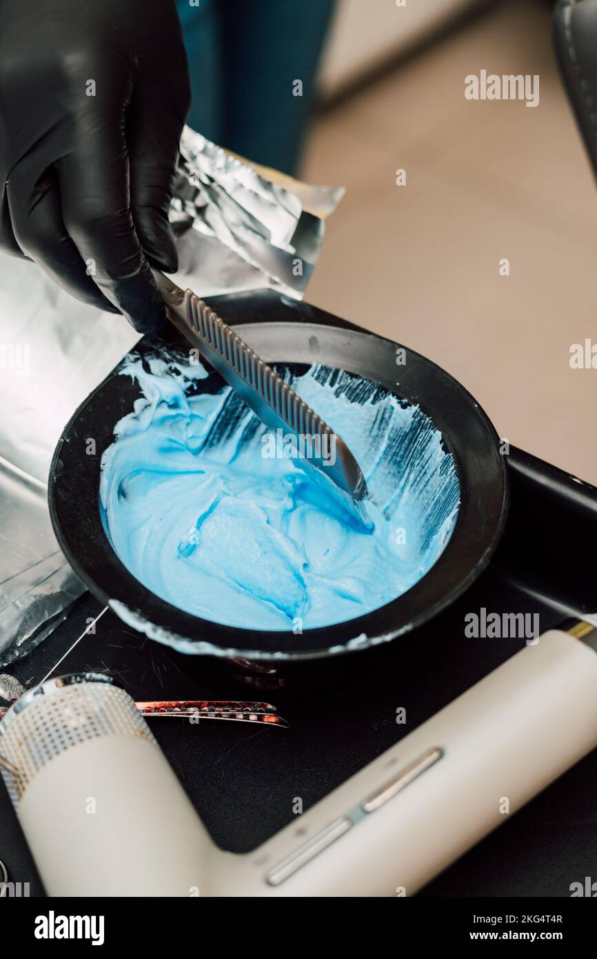 Un coiffeur professionnel mélange un colorant avec un oxydant. Coloration des cheveux Banque D'Images