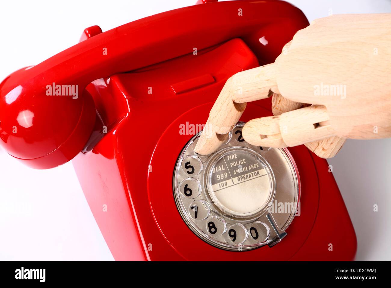 Main en bois utilisant un rétro rétro vieux téléphone rouge cadran Banque D'Images