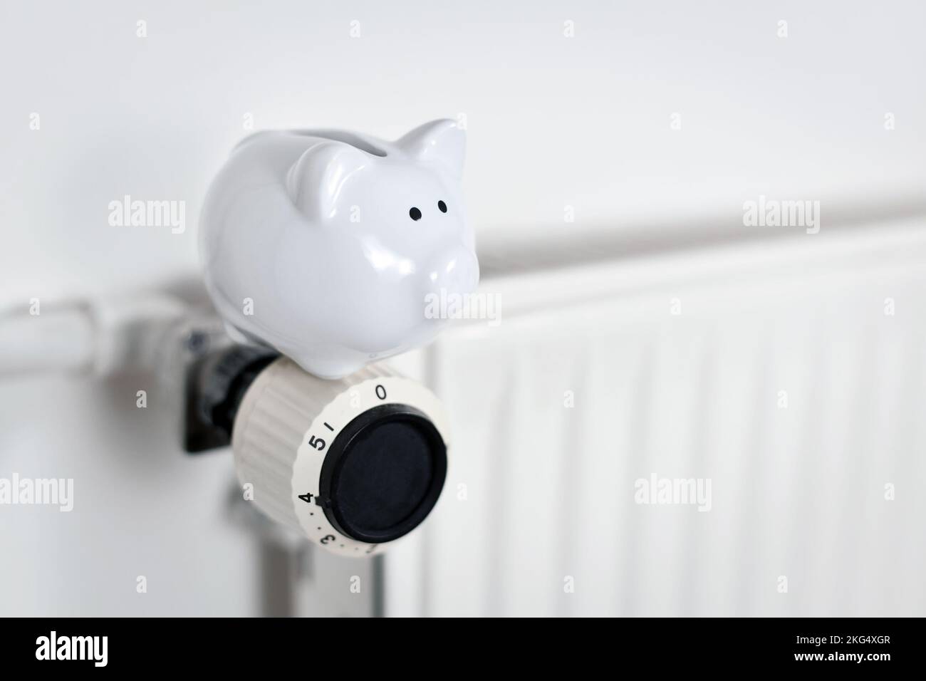 Économiser de l'argent pour le gaz pour le concept de chauffage avec la banque de porc sur le radiateur avec l'espace de copie Banque D'Images