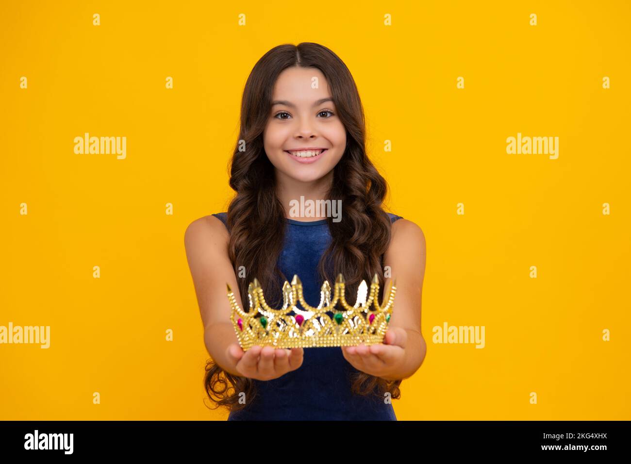 Petite reine portant une couronne dorée. Adolescente princesse tenant tiara couronne. PROM partie, concept d'enfance. Bonne fille visage, positif et souriant Banque D'Images