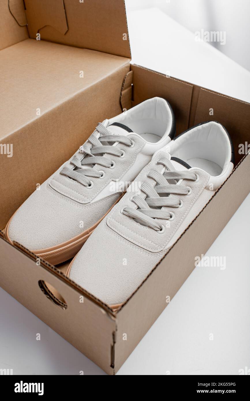 Nouvelles chaussures blanches dans la boîte. Décontracté homme chaussures sur fond blanc Banque D'Images