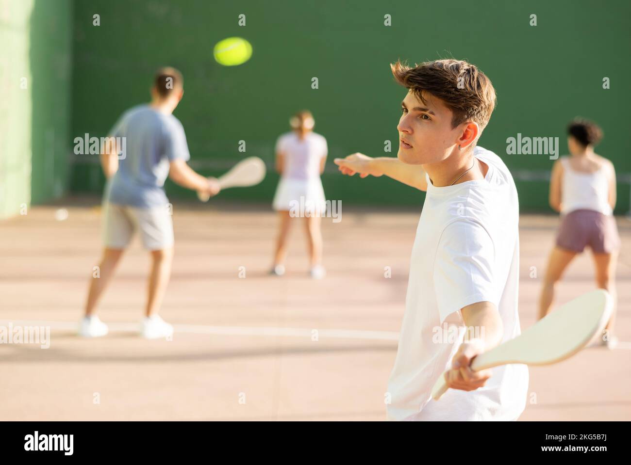 Jeune homme servant le ballon pendant le jeu de pelota basque en plein air Banque D'Images