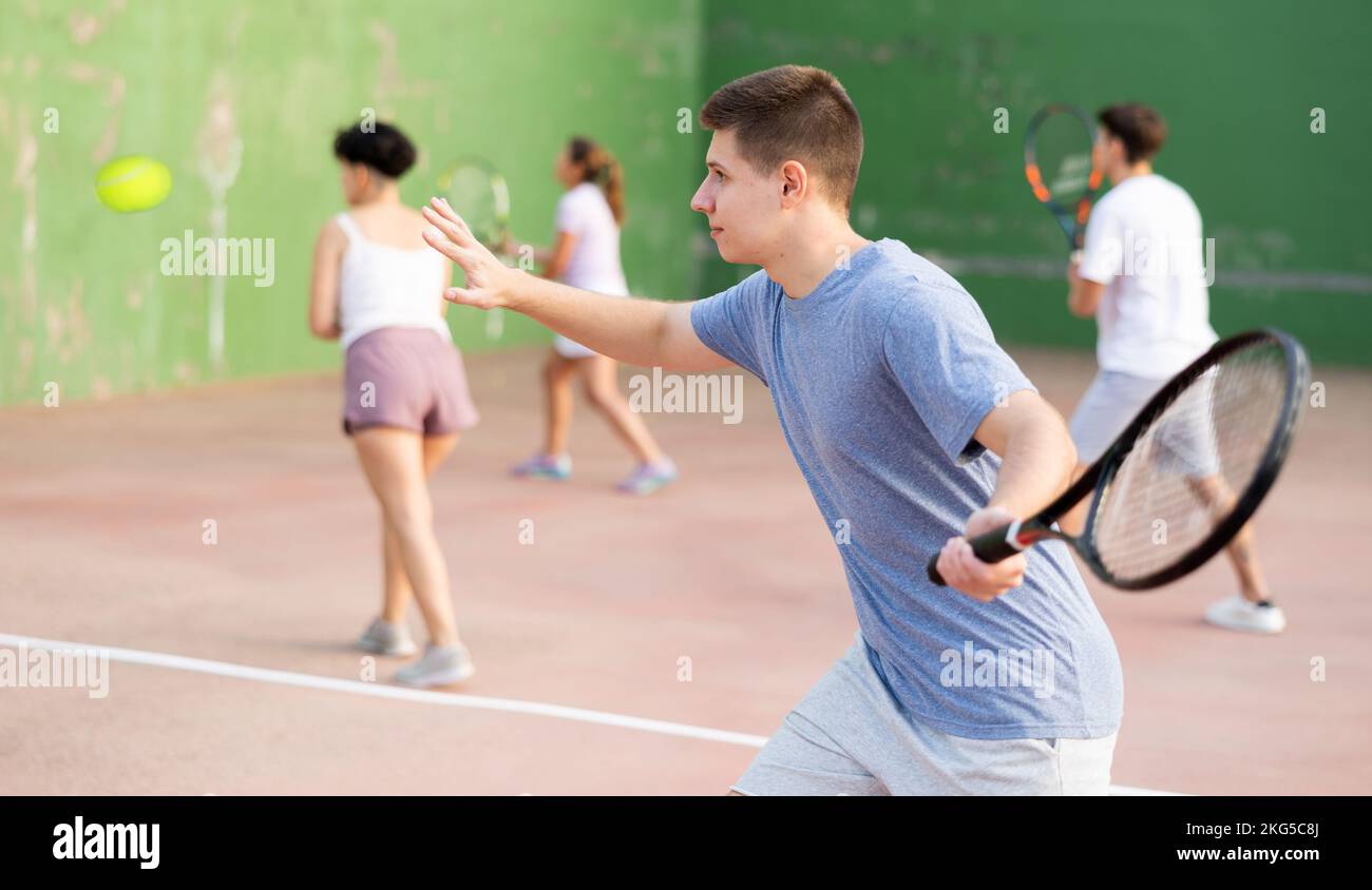 Jeune homme jouant frontenis sur un terrain de fronton en plein air en été Banque D'Images