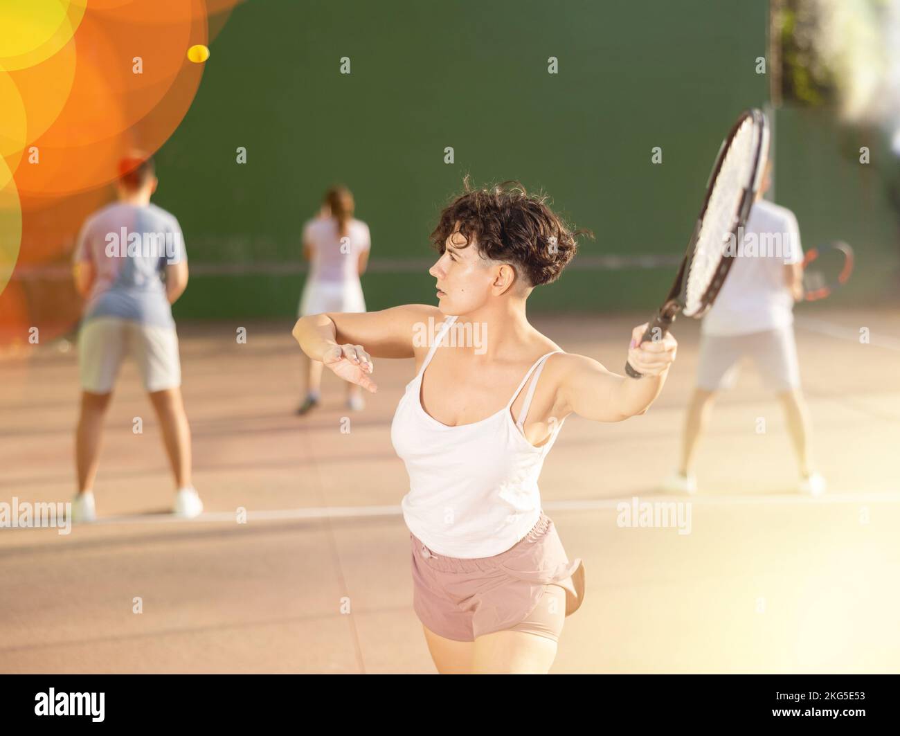 Femme sportive en short et t-shirt jouant frontenis sur le terrain Banque D'Images