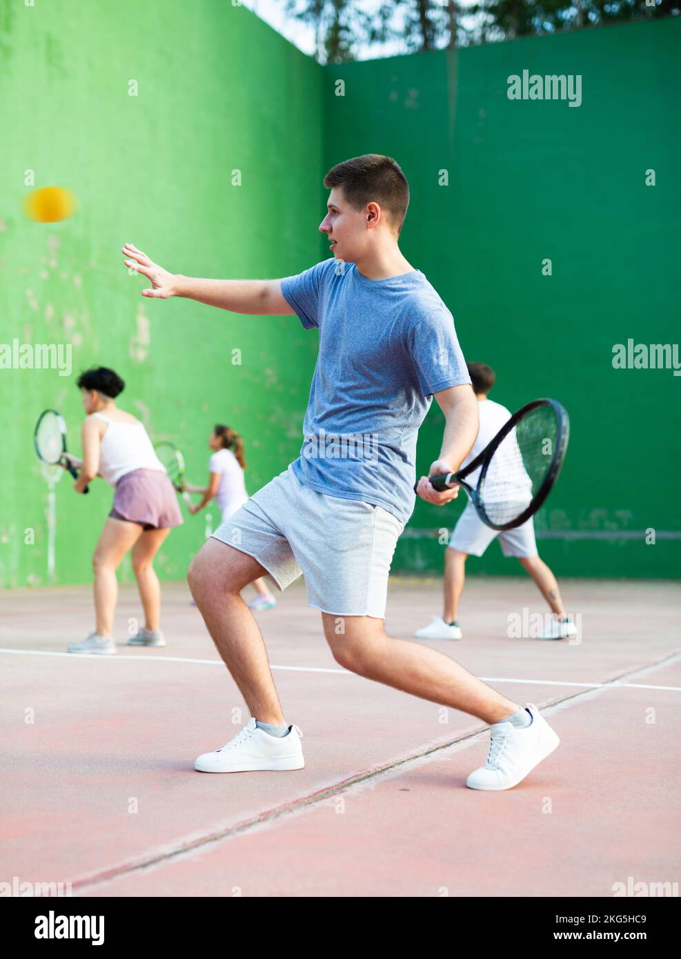 Jeune homme jouant frontenis sur un terrain de fronton en plein air en été Banque D'Images