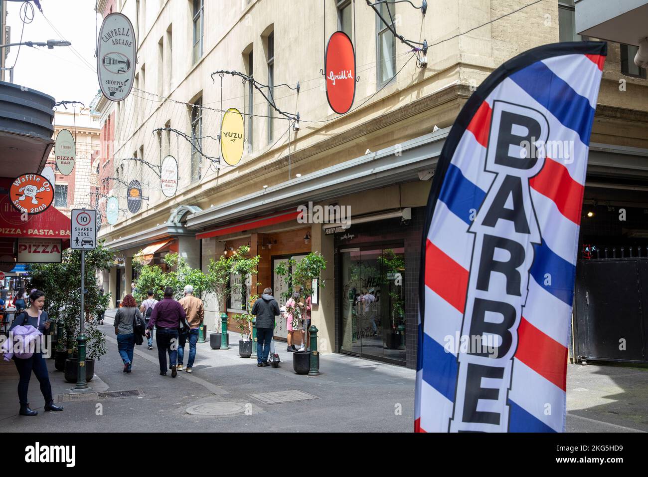 La voie de Melbourne, dégrade la rue avec des magasins de nourriture et des cafés et le magasin de barbiers, Melbourne, Victoria, Australie Banque D'Images