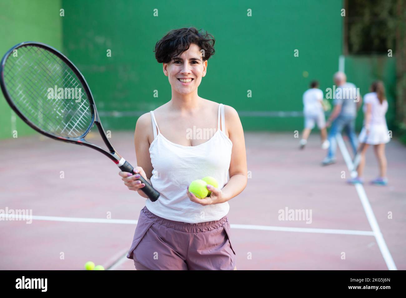 Portrait d'une femme latino debout sur le terrain de frontenis, tenant la raquette et le ballon Banque D'Images