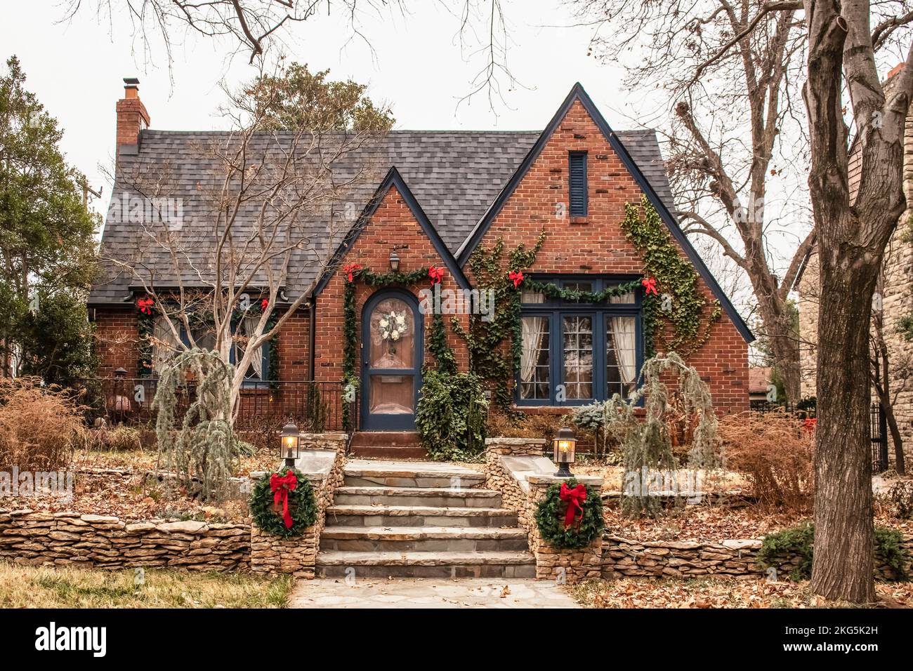 Mignon chalet en brique rouge avec des arcs et de verdure - Décorées pour Noël en hiver sombre Banque D'Images