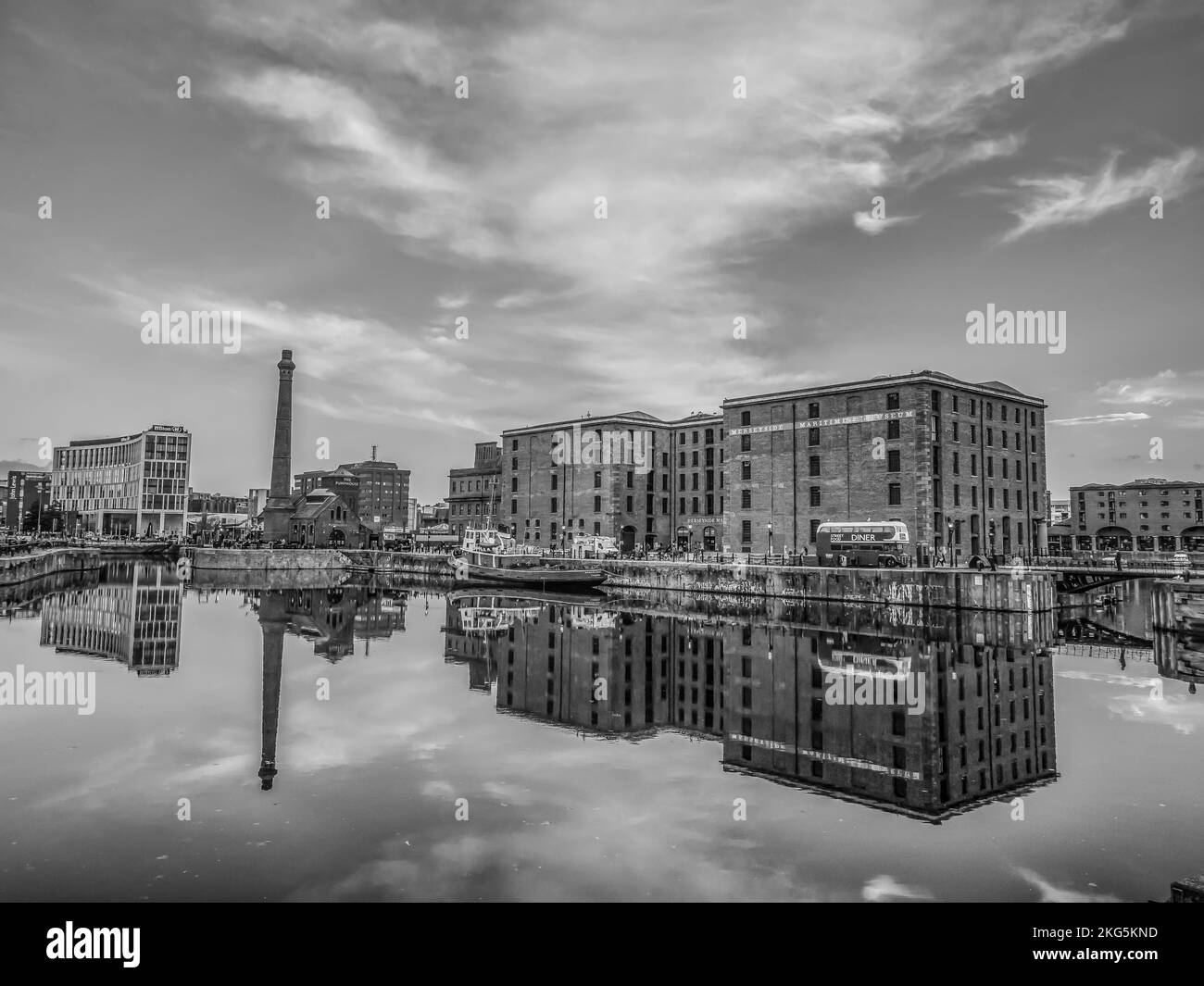 Scènes de rue à Liverpool vues ici de la région d'Albert Dock en regardant de l'autre côté du quai jusqu'à la vieille cheminée du bâtiment de pompe de docks Banque D'Images