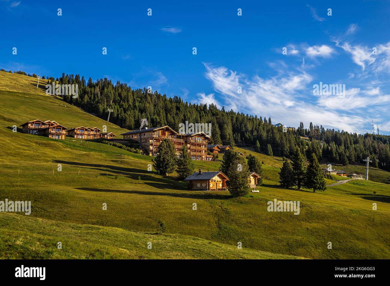 Seiser Alm, Italie - Hôtels et chalets en bois tyrolien et champs verts à Alpe di Siusi lors d'une journée d'été ensoleillée avec ciel bleu et nuages Banque D'Images