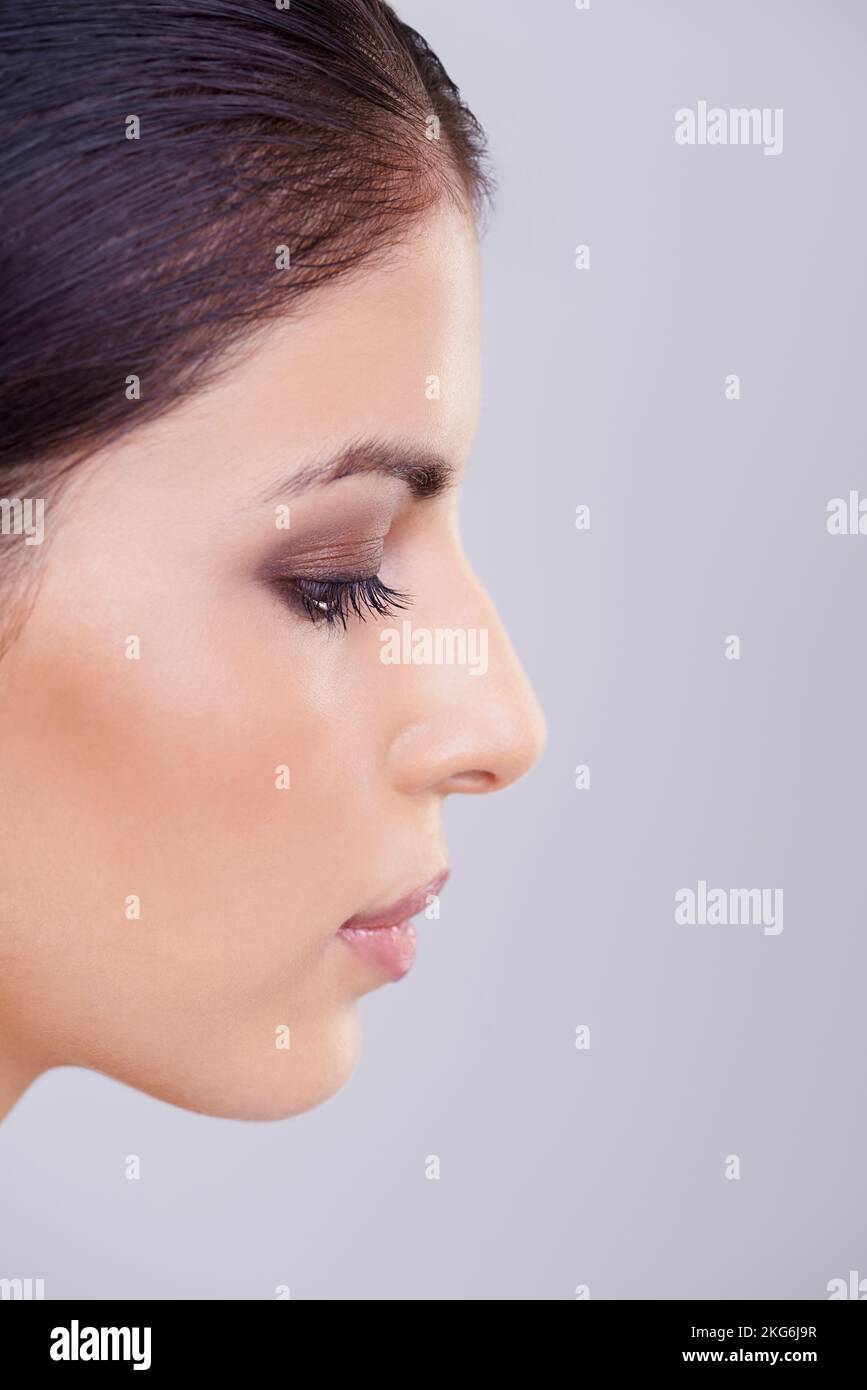Le profil de la beauté. Photo studio d'une belle femme brune sur fond gris. Banque D'Images