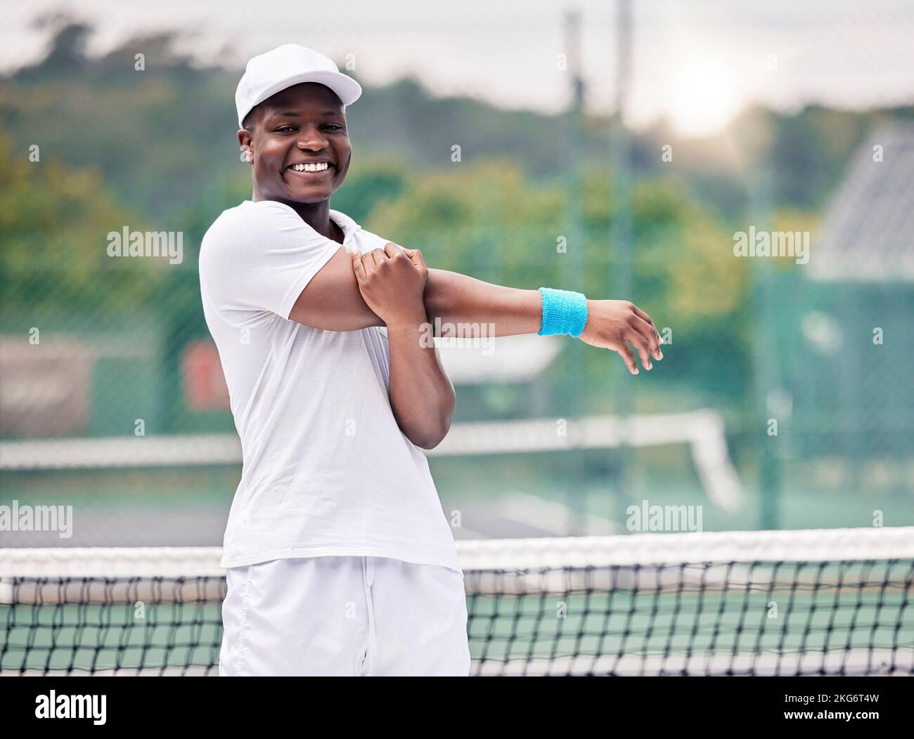 Homme noir, sur le court et s'étirant avant le jeu de tennis, sourire et pratiquer pour le bien-être, la santé et le plaisir en plein air. Portrait, Afro-américain ou Banque D'Images