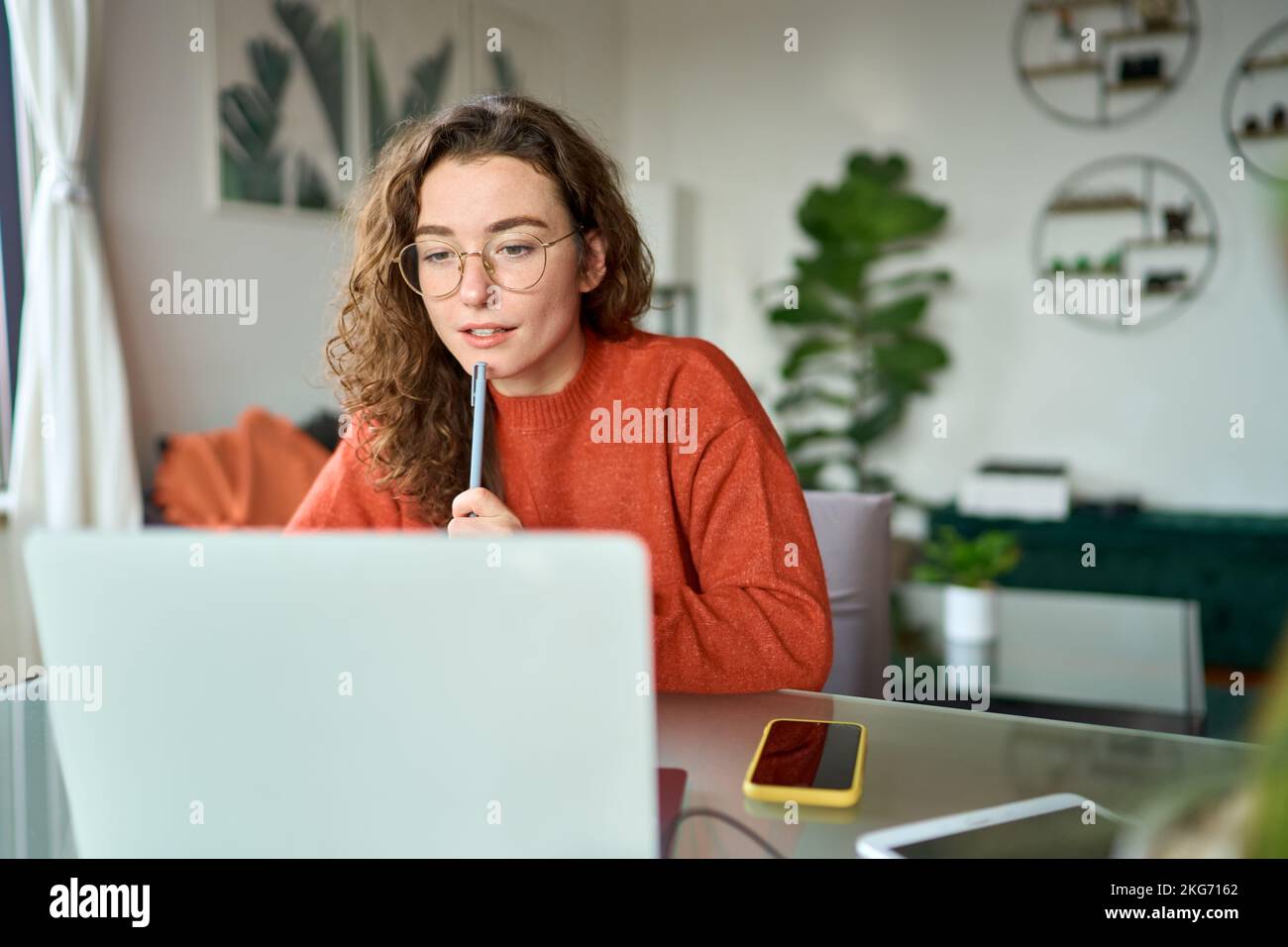 Jeune fille étudiante regardant un ordinateur portable regardant un webinaire en ligne apprenant à la maison. Banque D'Images