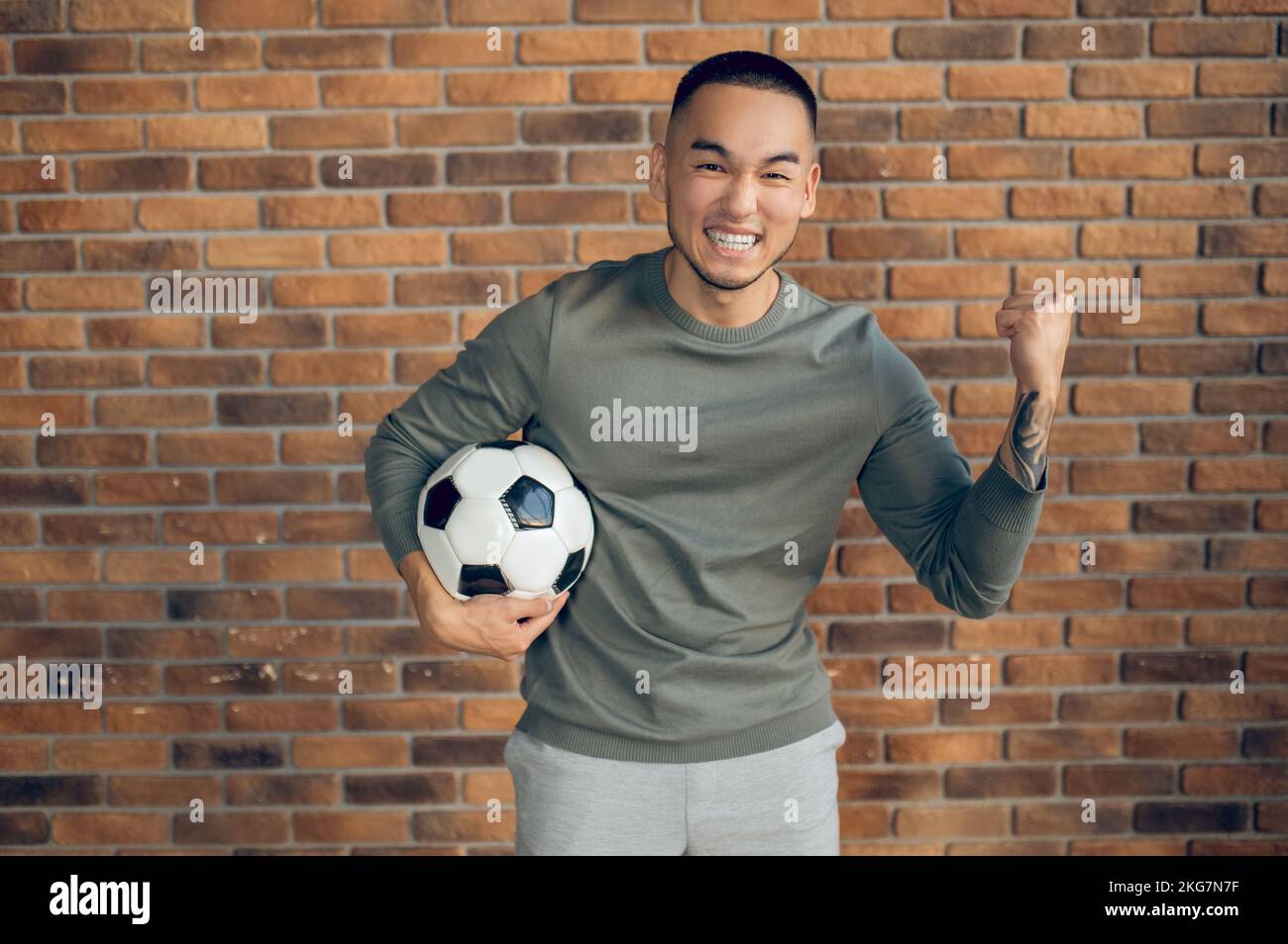 Un footballeur souriant et souriant qui fait un geste de célébration devant la caméra Banque D'Images