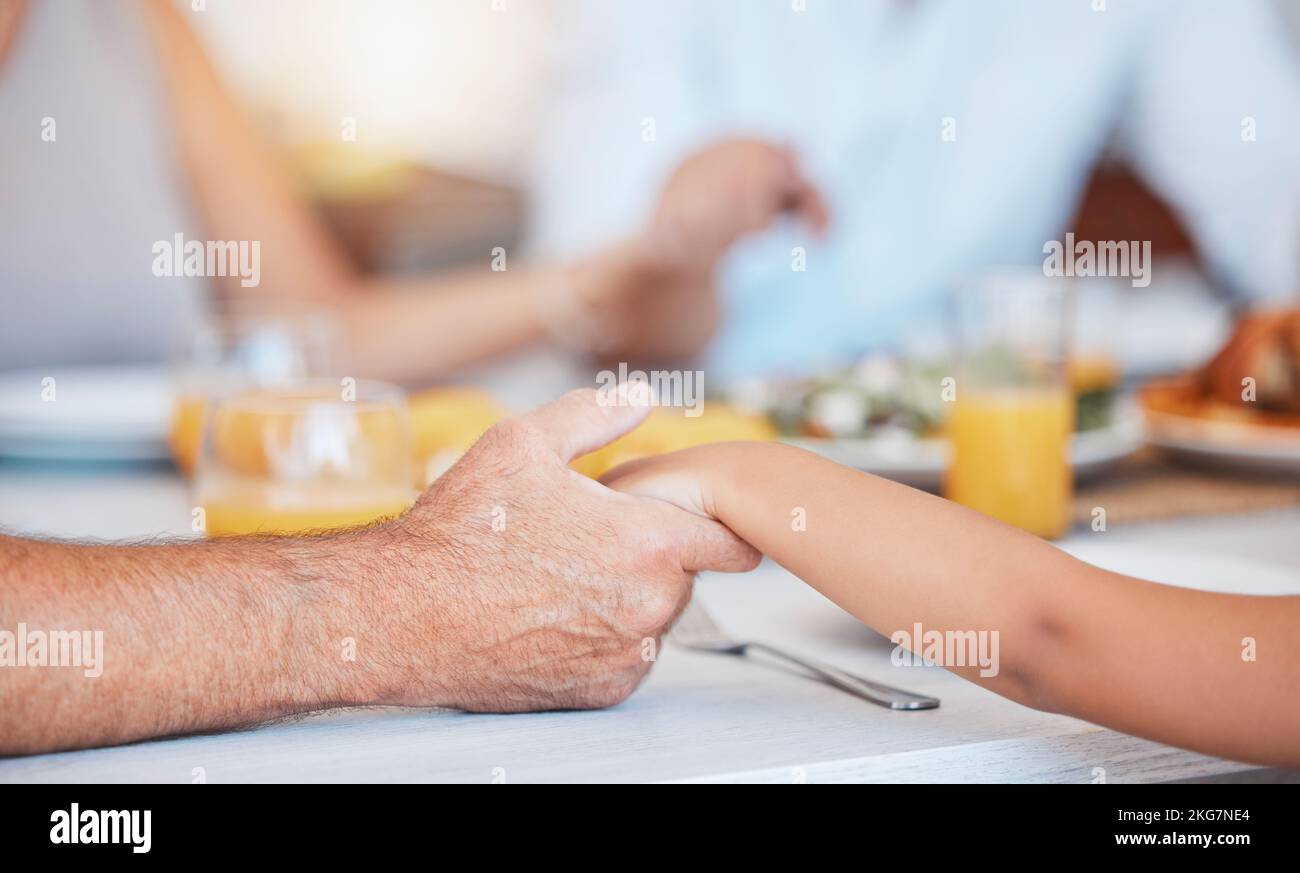 Famille, mains et gratitude prière pour la nourriture à table ensemble pour la foi, la religion et l'appréciation. Chrétien, enfant et homme âgé tenant la main à Banque D'Images