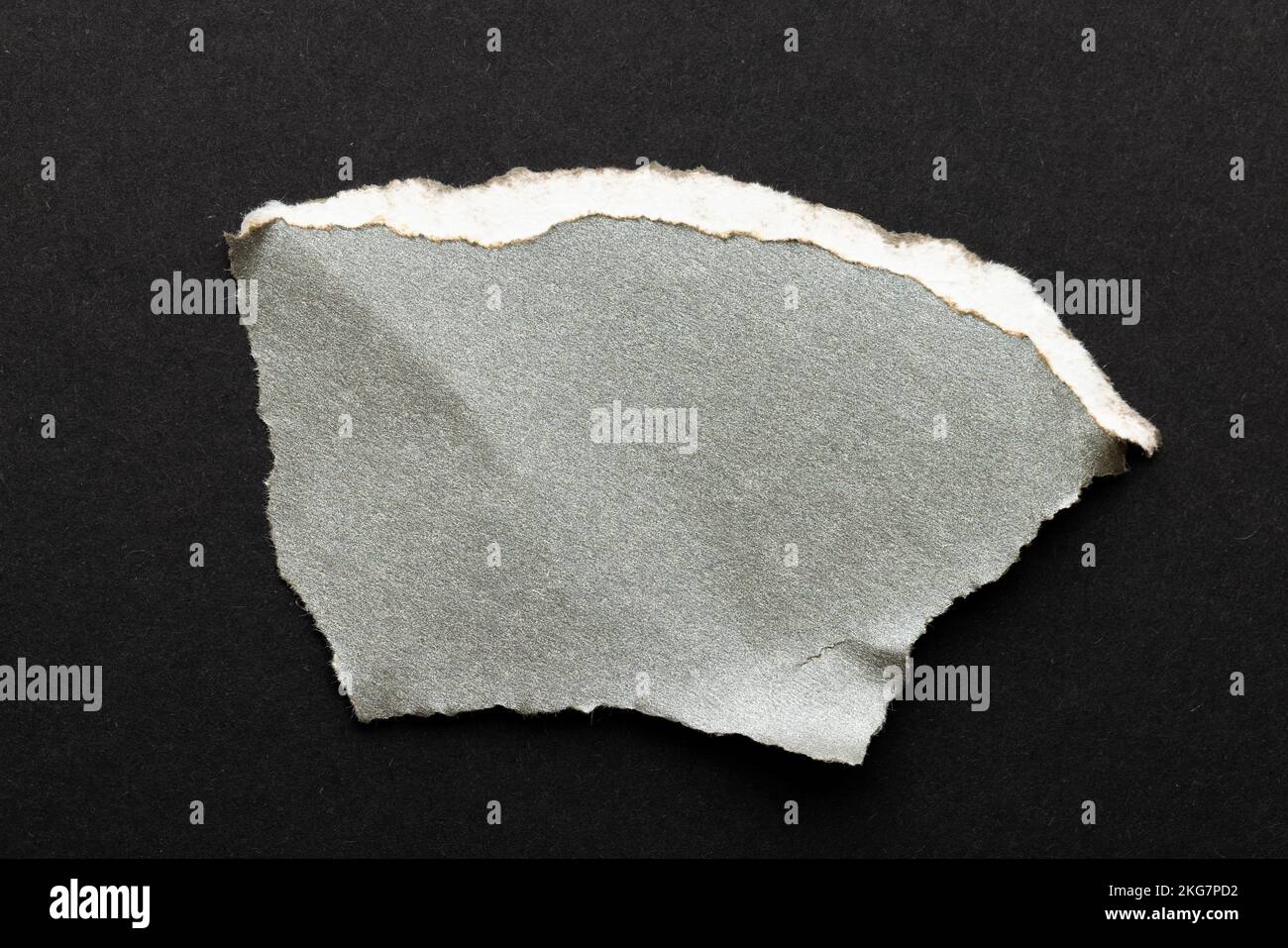 Morceau de papier gris déchiré avec espace de copie sur fond noir Banque D'Images