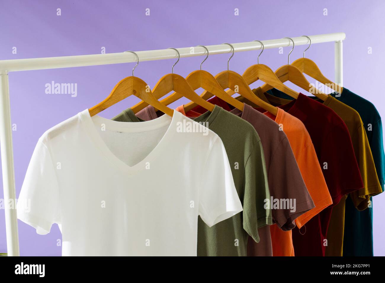 T-shirts de couleur sur le rail de vêtements et espace de copie sur fond violet Banque D'Images