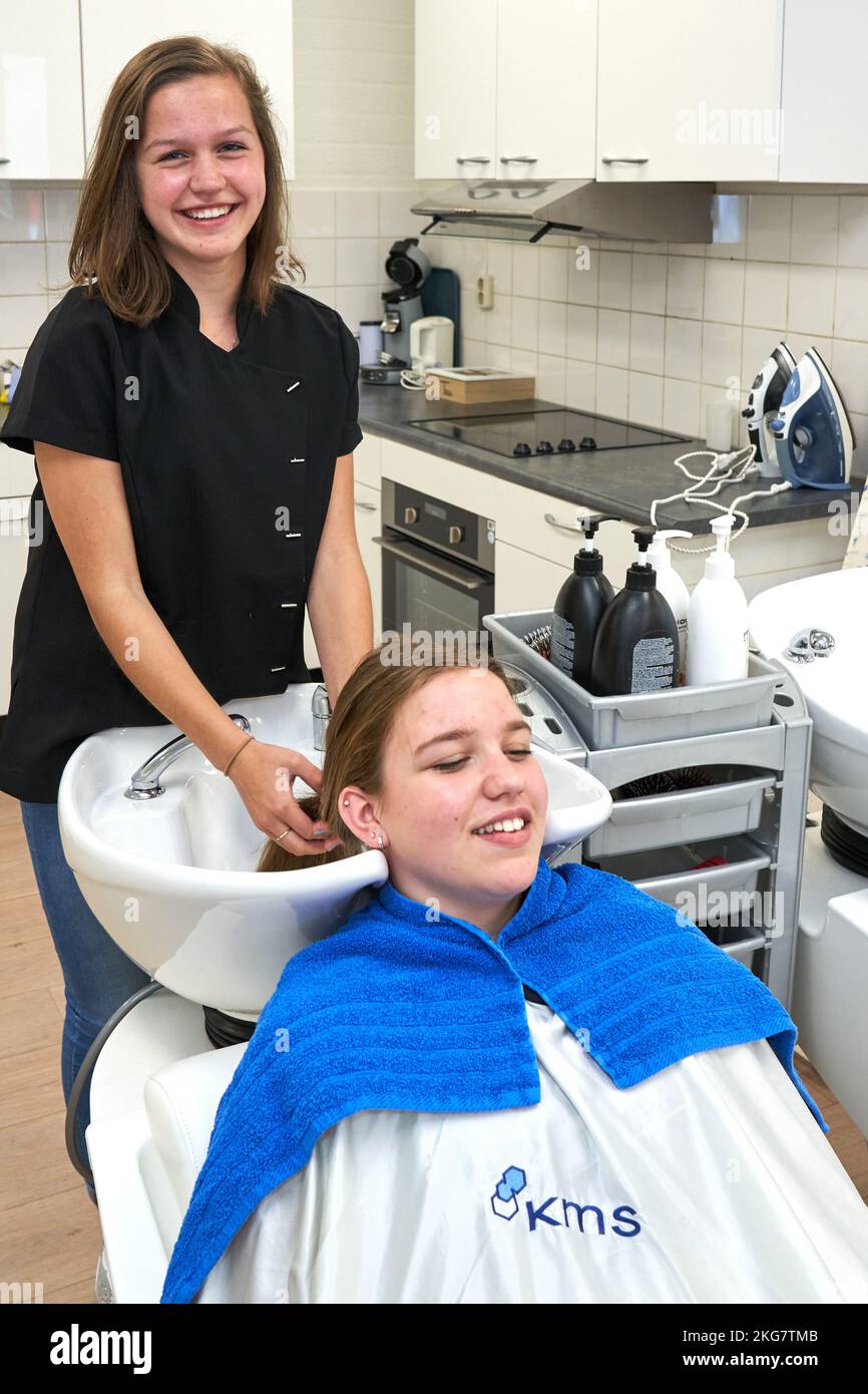 Une étudiante de sexe féminin se lavent les cheveux de l'élève pendant la prise en charge de la leçon dans le cadre d'une éducation secondaire. Duiven 2022 vvbvanbree fotografie Banque D'Images