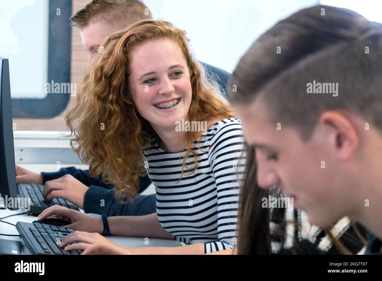 Étudiant avec des cheveux rouges travaillant dans une salle de classe avec un ordinateur dans une école secondaire. Pays-Bas. fotografie vvbvanbree. Banque D'Images