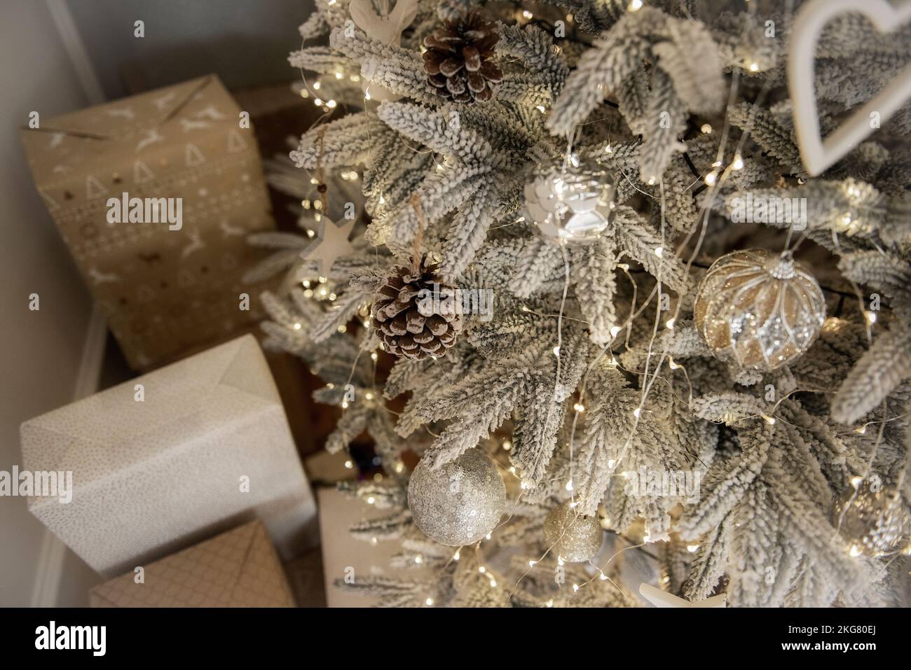 Parquet, laminé, boîtes avec cadeaux en papier blanc d'or artisanal sous l'arbre de Noël. En attendant Noël, le Père Noël. Luxe artificiel Chr Banque D'Images