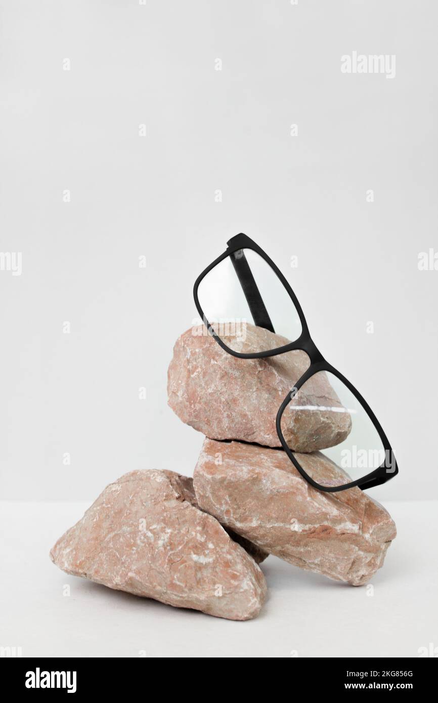 lunettes sur fond gris wjth pierre. vente de lunettes concept. Copier l'espace pour le texte. Affiche de réduction pour magasin optique. Banque D'Images